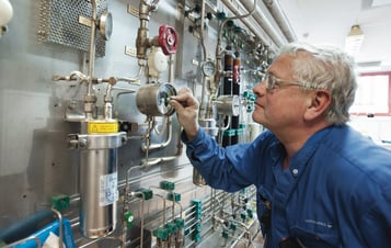 En manlig medarbetare på Idbäcksverket kontrollerar mätinstrument