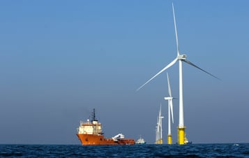 Ett fartyg intill en havsbaserad vindkraftspark