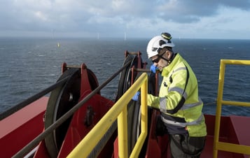 Man som arbetar med att installera vindkraftverk till havs
