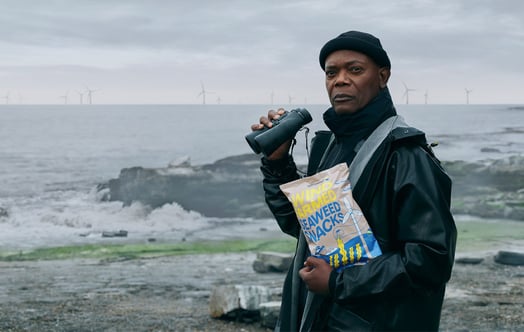 Samuel L. Jackson med en påse tångsnacks framför en havsbaserad vindkraftspark