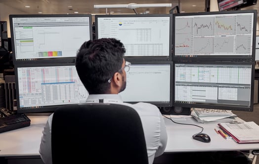 En anställd på Vattenfalls trading-avdelning vid sitt skrivbord med flera skärmar
