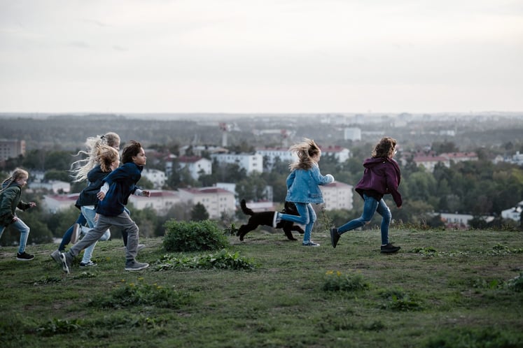 En grupp barn som springer på en kulle En grupp barn som springer på en kulle