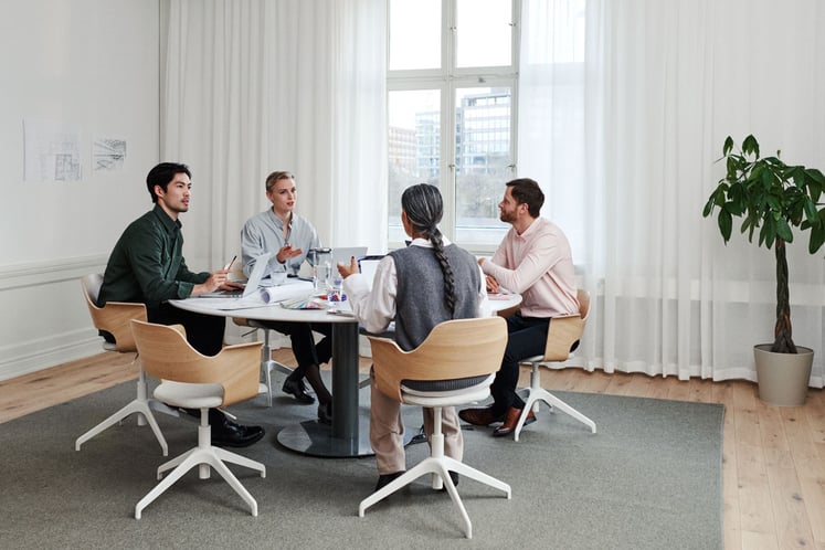 Fyra personer i möte runt ett bord