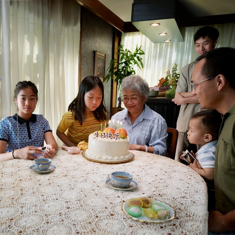 En familj sitter samlad runt ett bord 