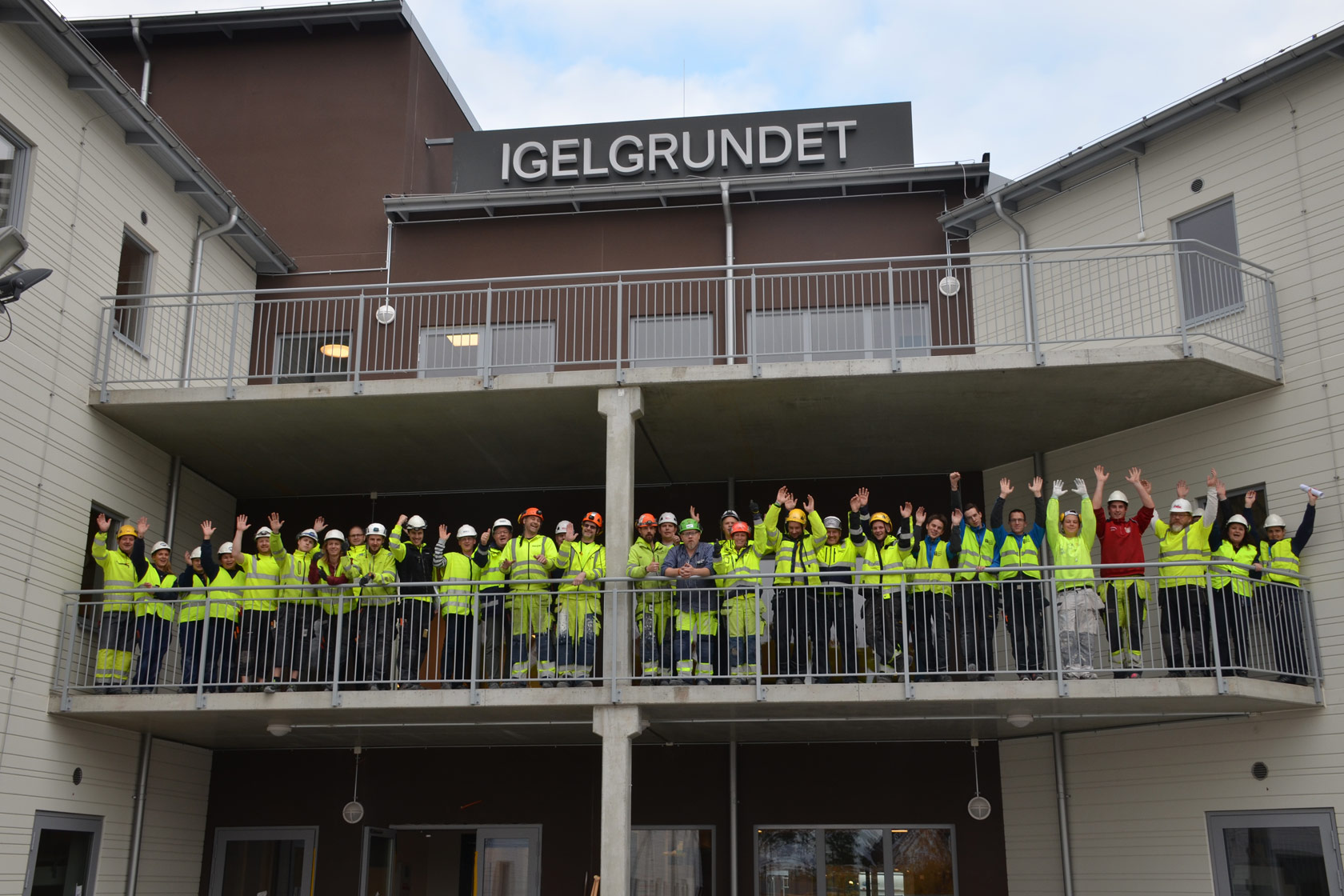 A group of contractors waving from the staff accommodation Igelgrundet at Forsmark