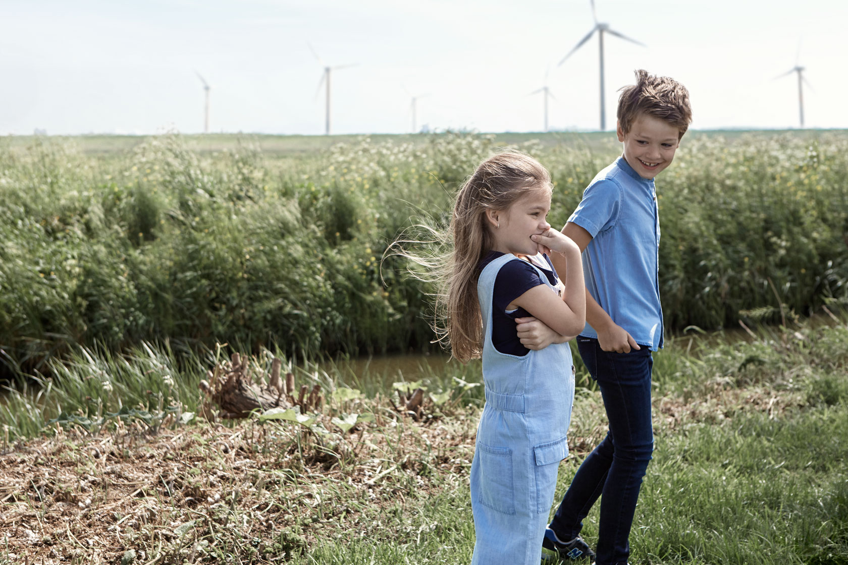 Två barn framför en vindkraftspark