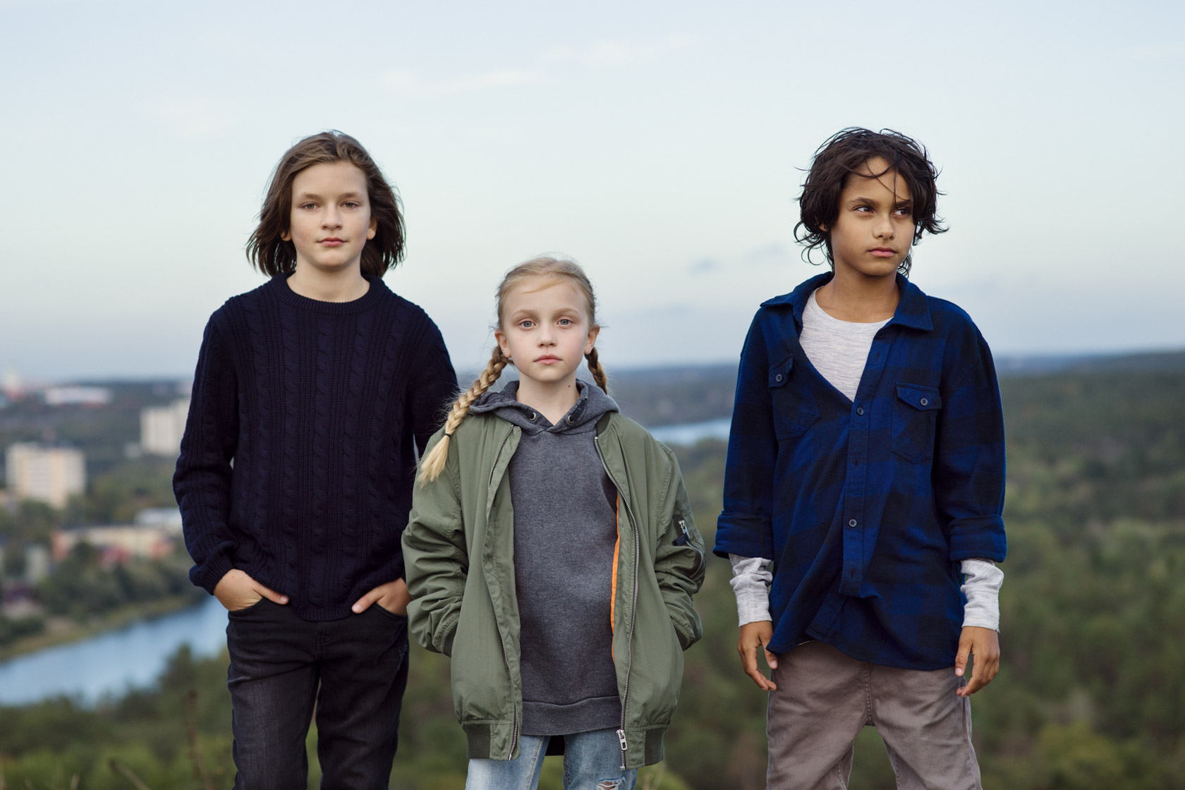 Tre barn uppe på en kulle