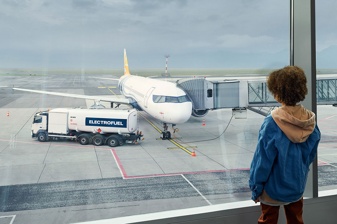 Ett barn som tittar på ett plan på en flygplats