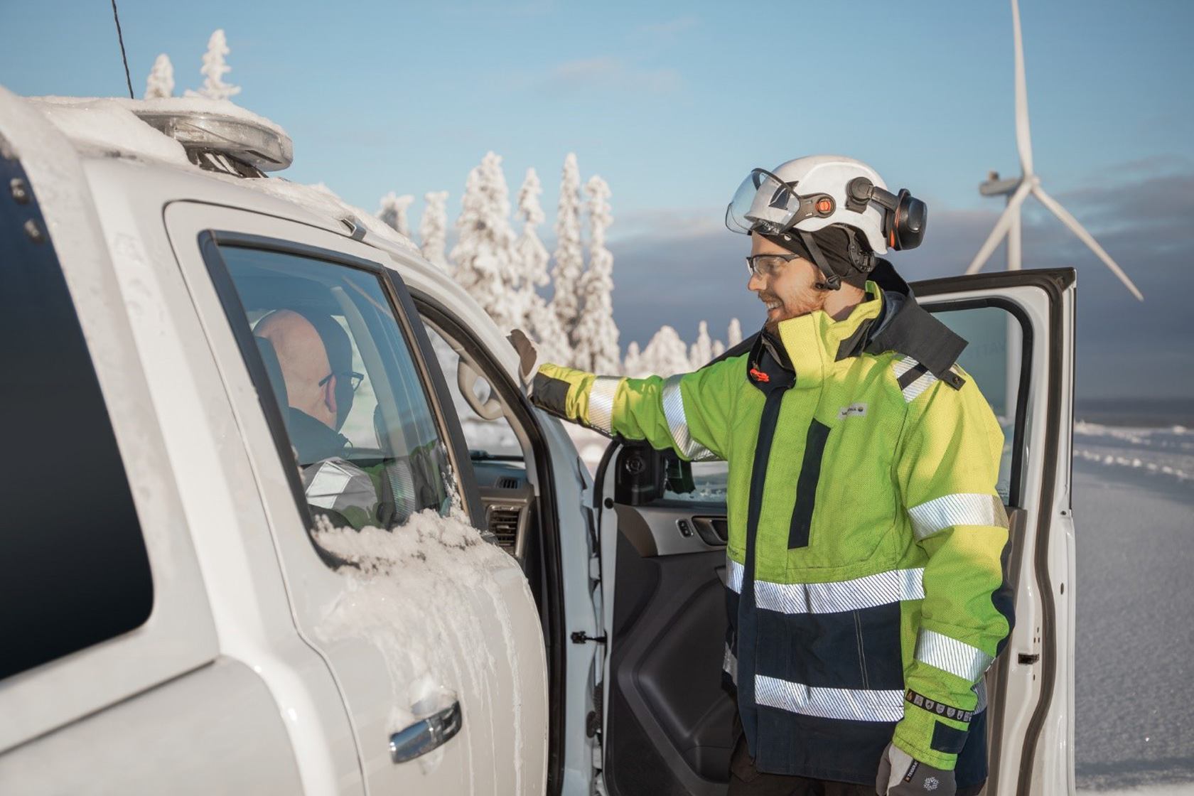 Medarbetare vid Blakliden Fäbodberget samtar med kollega i bil en vinterdag