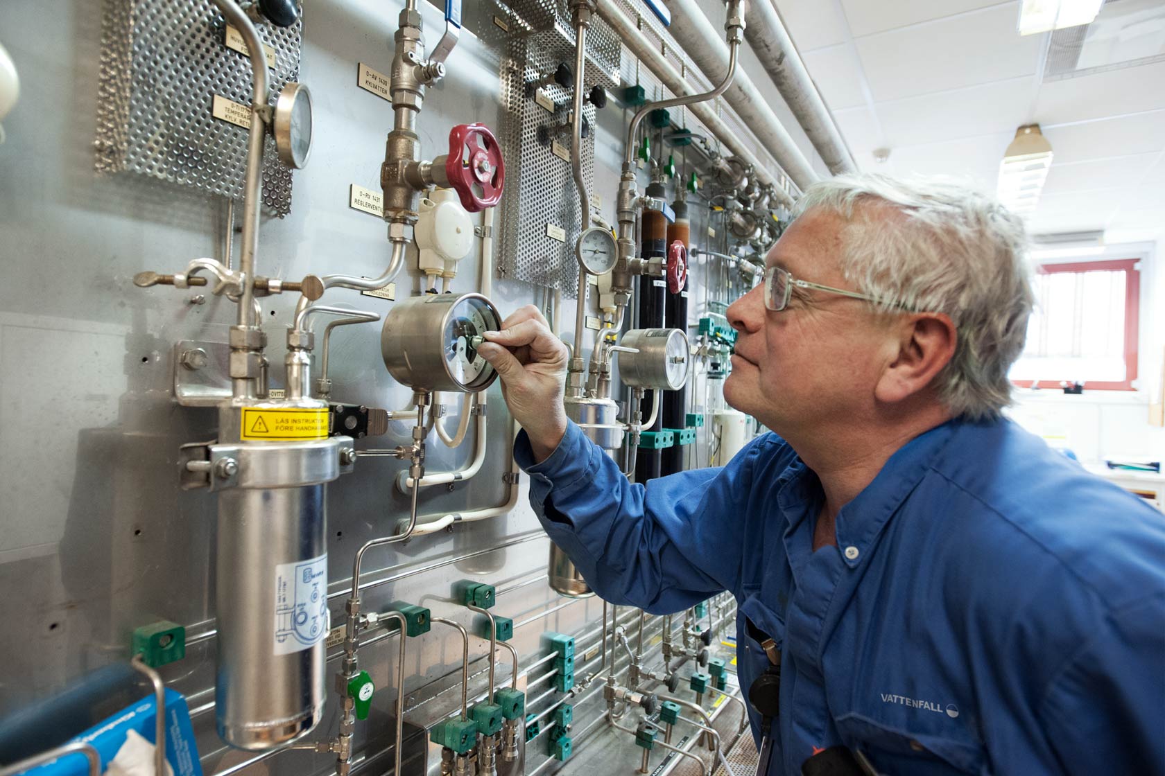 Male employee adjusting gauge at CHP plant Idbäcksverket