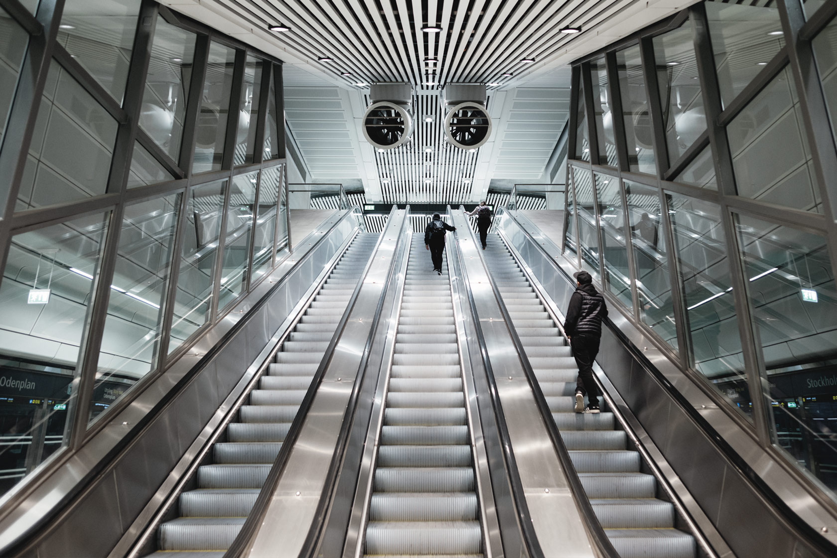 People going up escalators in a train station