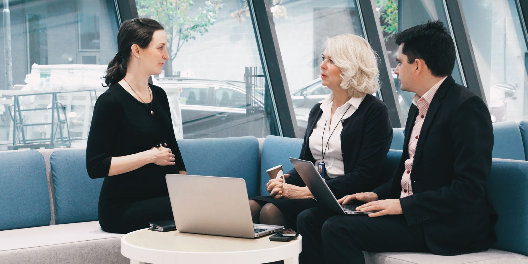A pregnant employee talking to two colleagues A pregnant employee talking to two colleagues