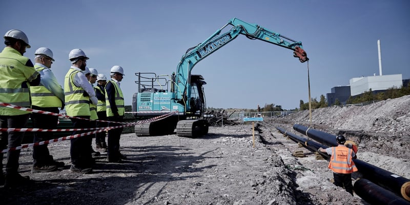 The signed pipe being lifted into the trench.