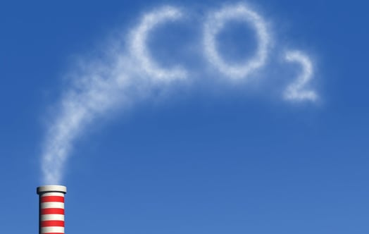 Red-and-white striped chimney emits white smoke forming “CO2” against a clear blue sky. Red-and-white striped chimney emits white smoke forming “CO2” against a clear blue sky.