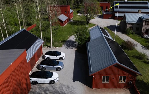 Electric cars parked between red wooden houses in the Stenberg housing association. Electric cars parked between red wooden houses in the Stenberg housing association.