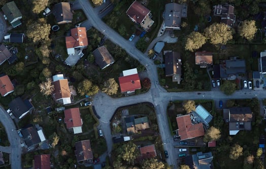 Aerial view of a residential neighbourhood with detached houses, intersecting streets, gardens and trees. Aerial view of a residential neighbourhood with detached houses, intersecting streets, gardens and trees.