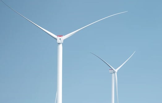 Two wind turbines against a clear blue sky. Two wind turbines against a clear blue sky.