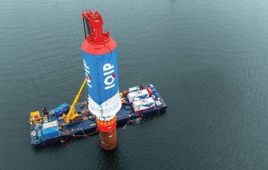 Offshore wind monopile being installed from a vessel at sea. Offshore wind monopile being installed from a vessel at sea.