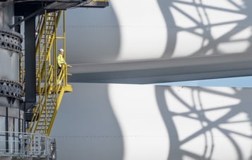 Ein Arbeiter blickt auf Komponenten einer Windkraftanlage in Hollandse Kust Zuid Ein Arbeiter blickt auf Komponenten einer Windkraftanlage in Hollandse Kust Zuid