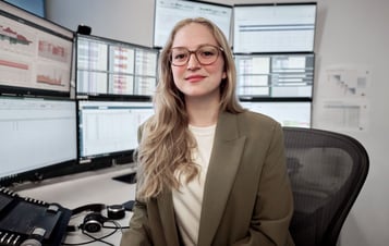 Frau sitz am Schreibtisch in Kamera blickend Frau sitz am Schreibtisch in Kamera blickend