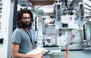 Ein Mann mit einem Klemmbrett steht neben einer Industrieanlage im Forschungs- und Entwicklungslabor von Vattenfall. Ein Mann mit einem Klemmbrett steht neben einer Industrieanlage im Forschungs- und Entwicklungslabor von Vattenfall.