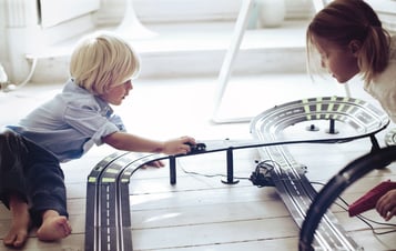 Kinder mit einer Carrerabahn spielend Kinder mit einer Carrerabahn spielend