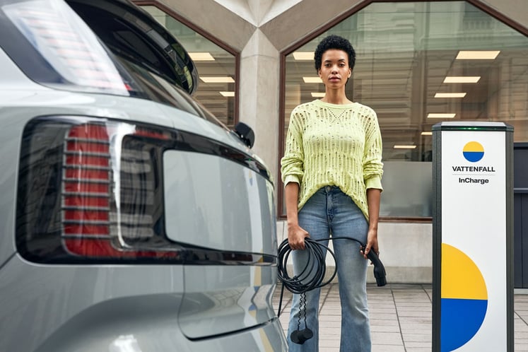 Eine Frau, die ein Ladekabel für ein Elektroauto in der Hand hält Eine Frau, die ein Ladekabel für ein Elektroauto in der Hand hält