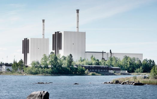Kärnkraftverket Forsmark, med vatten i förgrunden och träd runt anläggningen. Kärnkraftverket Forsmark, med vatten i förgrunden och träd runt anläggningen.