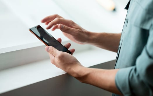 Närbild på händer och en mobiltelefon Närbild på händer och en mobiltelefon